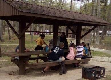 Students and presenter gathered at the bat station at the Eco Day at the Piney Wood Rec Area